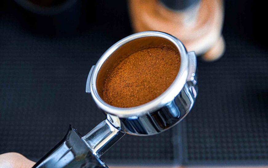 Puck screen placed on top of tamped espresso puck in a portafilter, ready for brewing an even espresso shot.